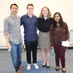 Group of students posing together indoor on campus during 2019 symposium