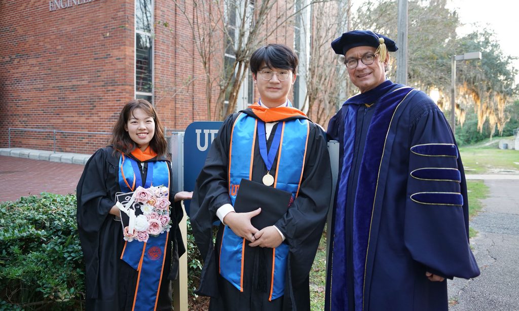 Cong Sun, left, and her husband, Yunhan Chuai, pose with Professor Mark Orazem during a graduation ceremony. Photo courtesy of Yunhan Chuai