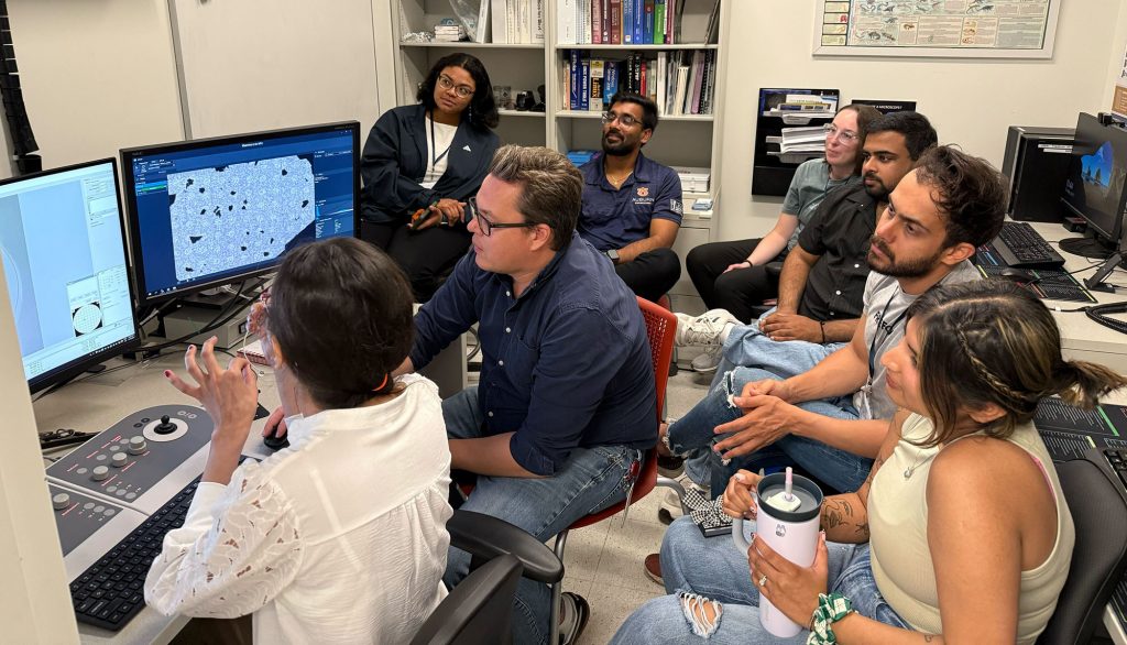Elizabeth Aikman (back right) and her classmates look at the crystalline structure of gold nanoparticles on the transmission electron microscope.