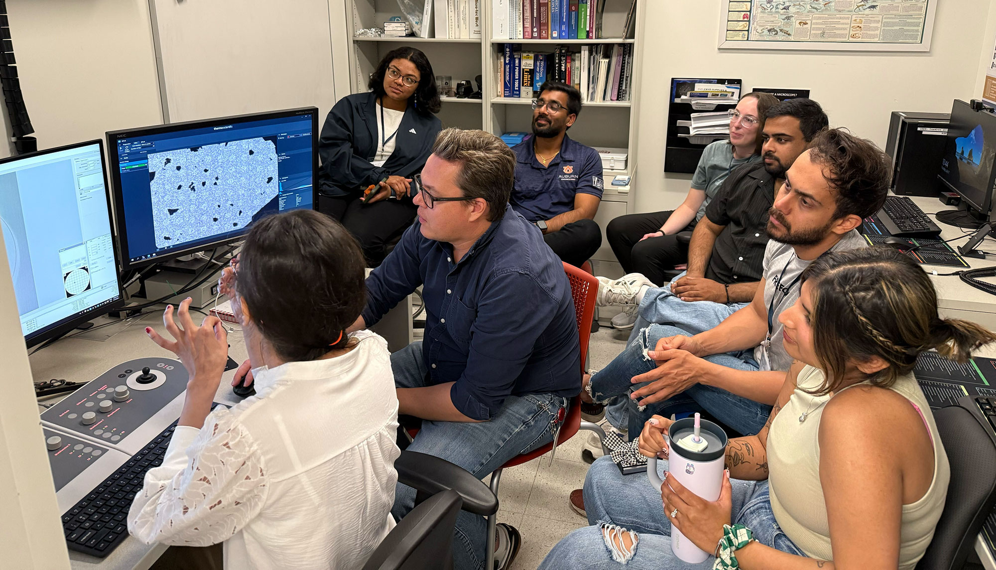 Elizabeth Aikman (back right) and her classmates look at the crystalline structure of gold nanoparticles on the transmission electron microscope.